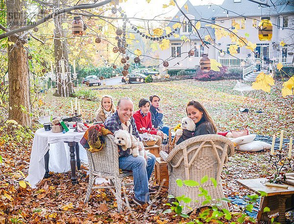 Porträt eines reifen Paares mit Teenagern und erwachsenen Kindern beim Picknick im Garten