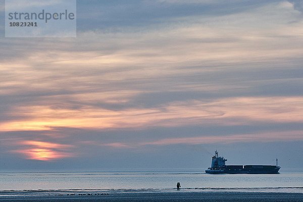 Schiff und zwei Personen am Crosby Strand bei Sonnenuntergang  Merseyside  England