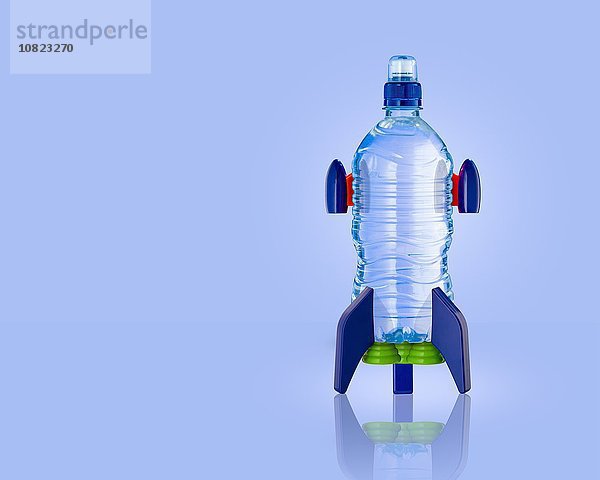 Stehende Wasserflaschenrakete mit blauem Hintergrund