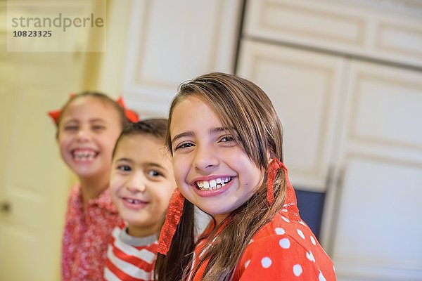 Schrägansicht von Kindern im Pyjama mit lächelndem Blick auf die Kamera