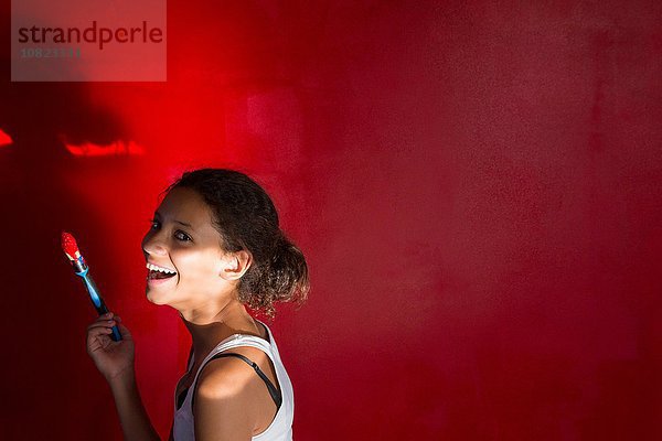 Porträt eines lachenden Mädchens vor roter Wand