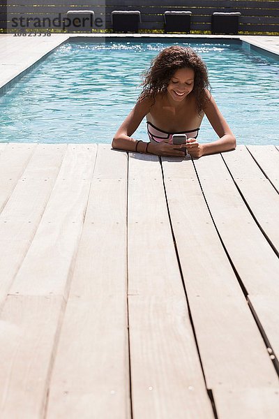 Mädchen im Schwimmbad beim Lesen von Smartphone-Texten  Cassis  Provence  Frankreich