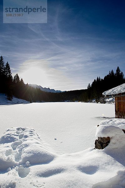 Sonnige Landschaft mit schneebedecktem See  Berg  Bayern  Deutschland