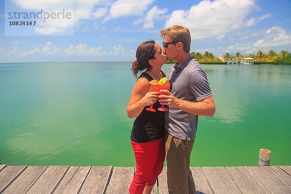 Romantisches Pärchen beim Küssen am Pier  St. Georges Caye  Belize  Mittelamerika