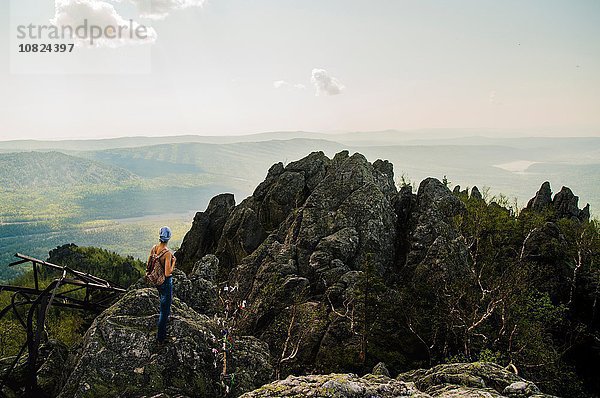 Rückansicht des Teenagers beim Wandern auf schroffen Felsformationen  Russland