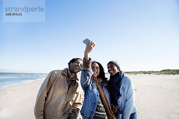 Drei Freunde am Strand  Selbstporträt  mit dem Smartphone