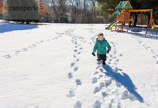 Hochwinkelansicht des Vorschulkindes auf dem Spielplatz beim Wandern im Schnee