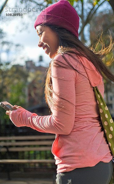 Junge Frau mit Smartphone im Park