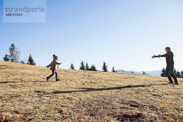 Kleinkind beim Laufen zum Vater am Berg  Tegernsee  Bayern  Deutschland