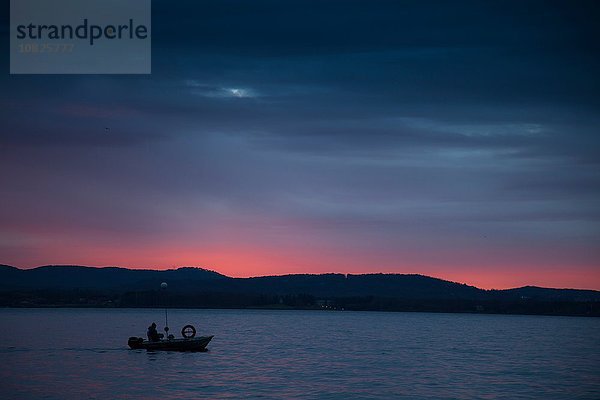 Silhouette eines kleinen Bootes auf dem Lago Maggiore  Piemont  Lombardei  Italien