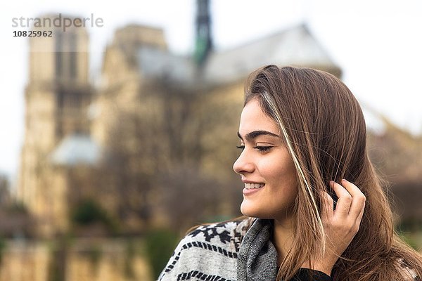Seitenansicht der jungen Frau  Kathedrale Notre Dame im Hintergrund  Paris  Frankreich