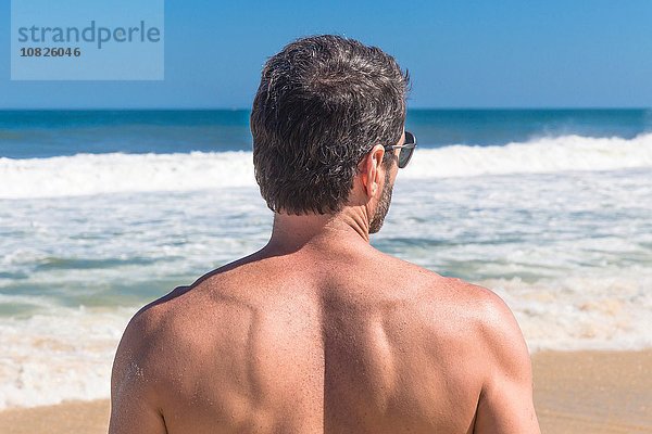 Reifer Mann mit Blick aufs Meer  Rückansicht  Ipanema  Rio de Janeiro  Brasilien