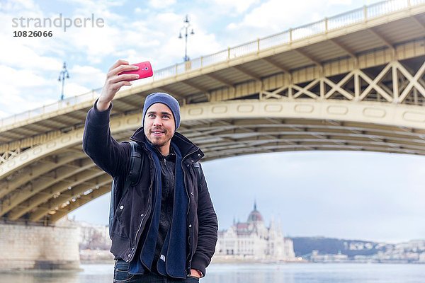 Tiefblick auf den jungen Mann vor der Margaretenbrücke mit dem Smartphone  Budapest  Ungarn