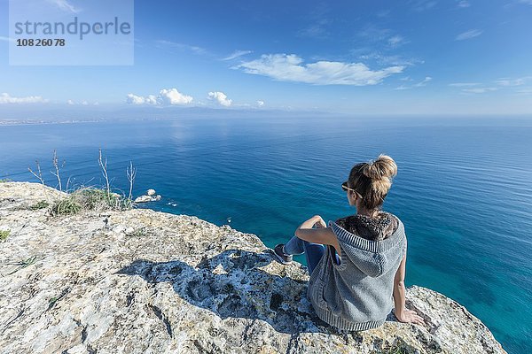 Rückansicht einer jungen Frau auf einer Klippe mit Blick auf das Meer  Cagliari  Sardinien  Italien