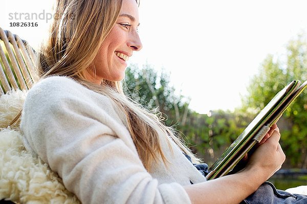 Porträt einer mittleren erwachsenen Frau mit digitalem Tablett  lächelnd