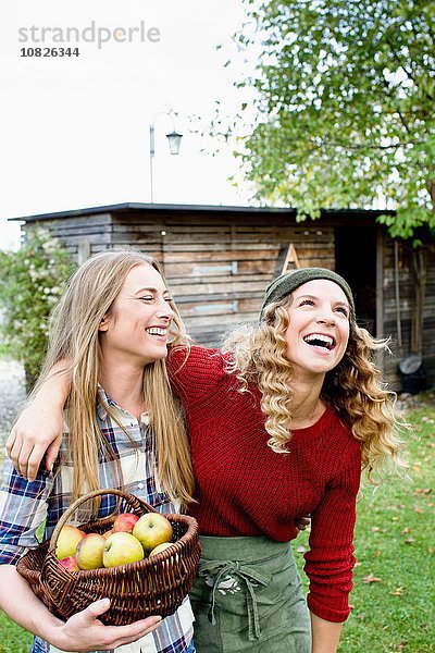 Zwei Frauen im Garten mit Apfelkorb  lachend