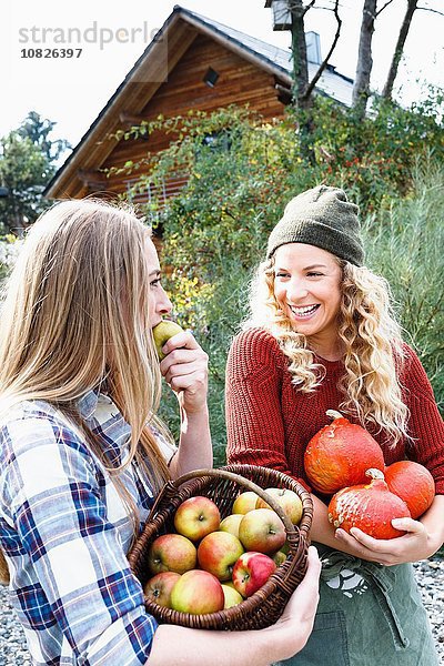 Zwei Freunde  die hausgemachte Produkte tragen  eine Frau  die Apfel isst.