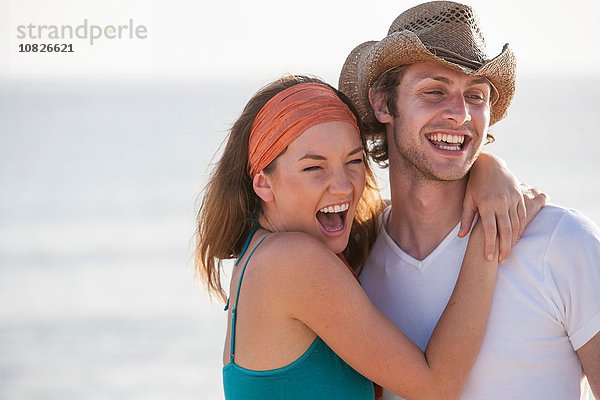 Porträt eines glücklichen jungen Paares am Meer