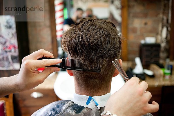 Rückansicht des jungen Mannes im Friseursalon mit Haarschnitt