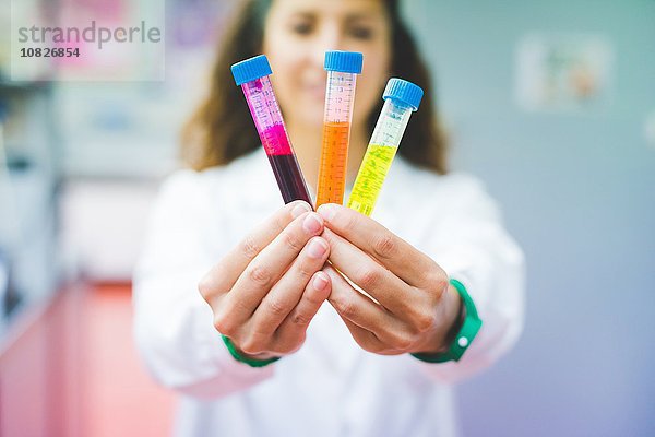 Wissenschaftlerin hält Lösung aus drei verschiedenen Fluoreszenzfarbstoffen