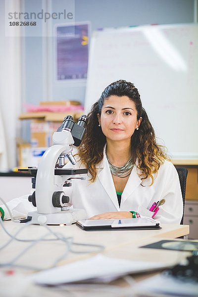 Wissenschaftlerin mit optischem Mikroskop