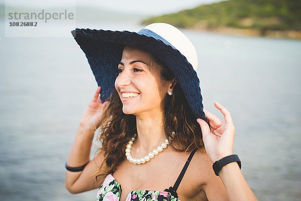 Frau am Meer  Hut tragend