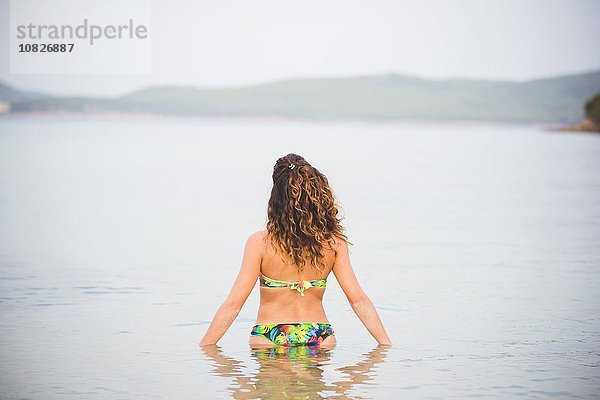 Frau im Meer  im Bikini  Rückansicht