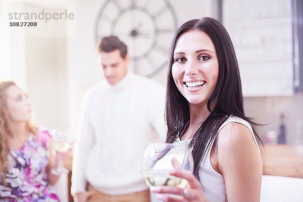 Porträt einer jungen Frau beim Weintrinken in der Küche