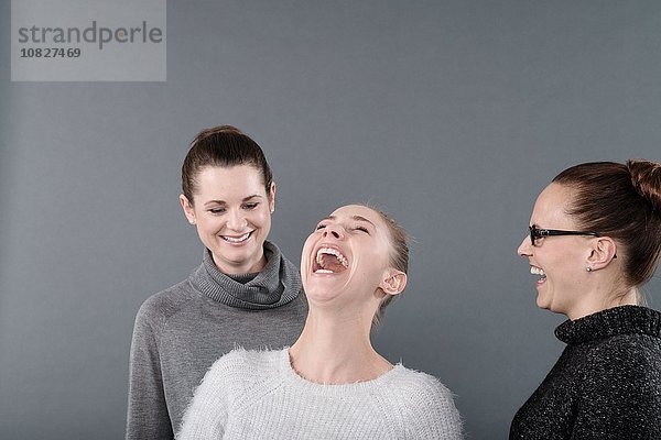 Junge Frauen lachend  grauer Hintergrund