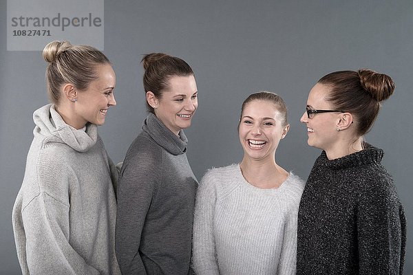 Junge Frauen lächeln  grauer Hintergrund