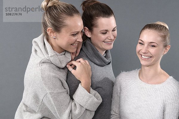 Junge Frauen lächeln  grauer Hintergrund