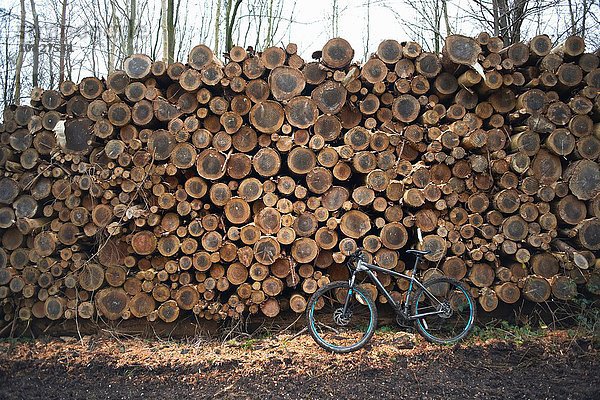 Fahrrad  das sich gegen einen Holzstapel lehnt