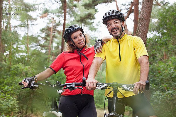 Portrait des glücklichen Mountainbike-Paares im Wald
