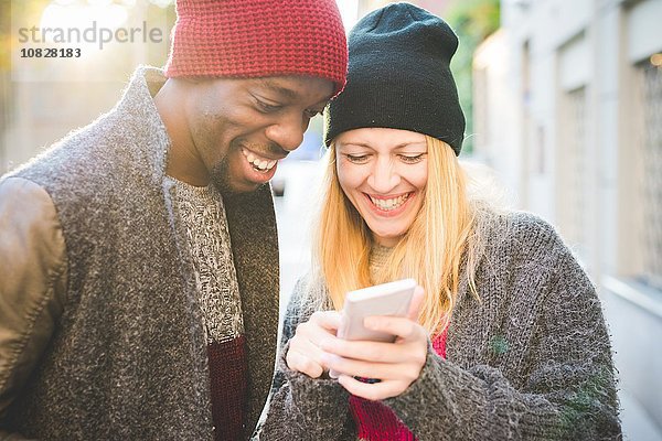Paar lächelt auf Nachricht auf dem Smartphone