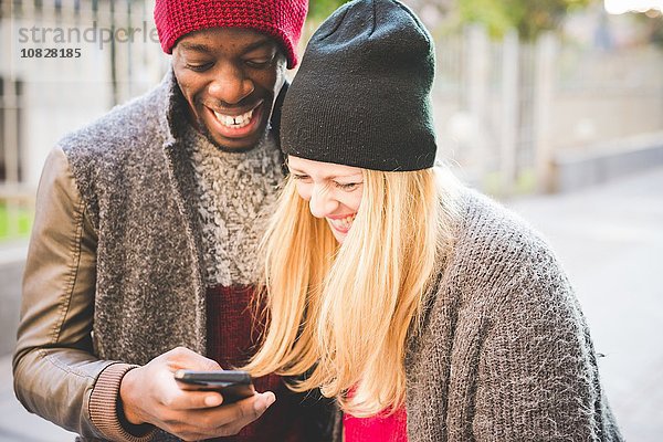 Paar lächelt auf Nachricht auf dem Smartphone