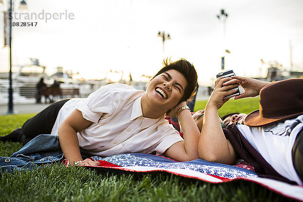 Asiatische Freunde liegen im Gras