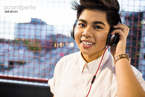 Asiatische Frau hört im Freien Kopfhörer