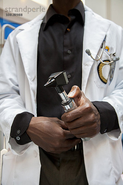 Nahaufnahme eines Arztes  der ein medizinisches Gerät im Krankenhaus hält