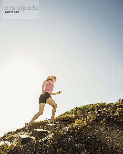 Kaukasische Frau joggt bergauf
