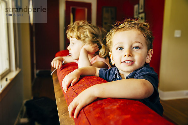 Kaukasische Kinder stehen auf dem Sofa