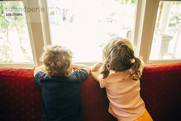 Kaukasische Kinder stehen auf dem Sofa