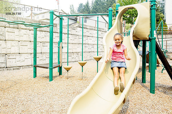 Gemischtrassiges Mädchen spielt auf dem Spielplatz