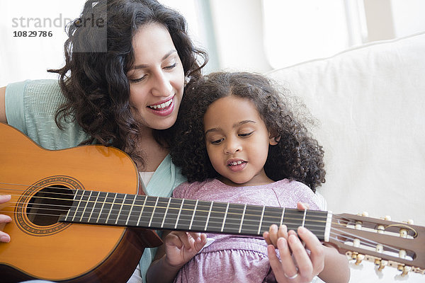 Mutter bringt Tochter Gitarre spielen bei