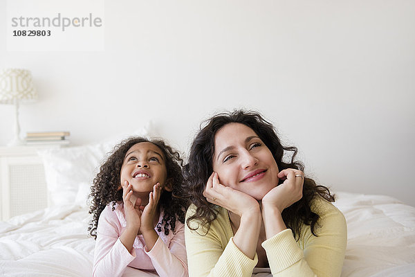 Mutter und Tochter träumen auf dem Bett