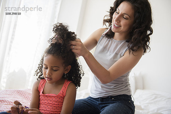 Mutter stylt die Haare ihrer Tochter