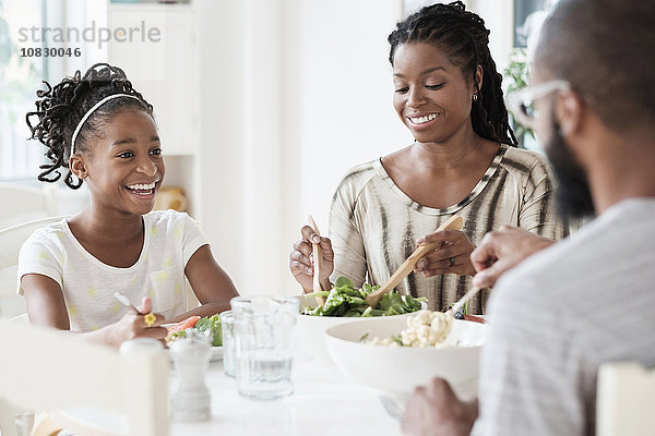 Schwarze Familie isst Salat am Tisch