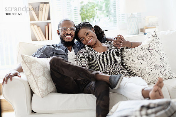 Schwarzes Paar lächelnd auf Sofa