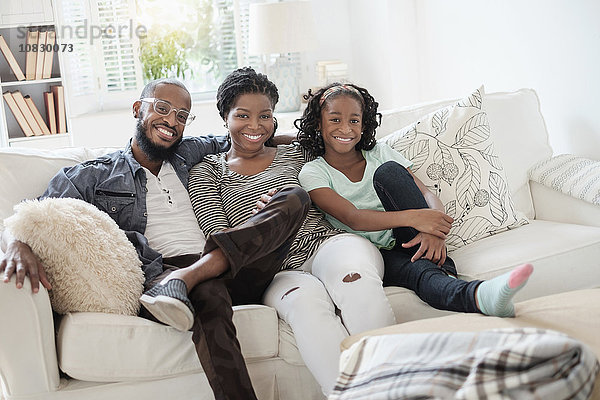 Schwarze Familie lächelnd auf Sofa