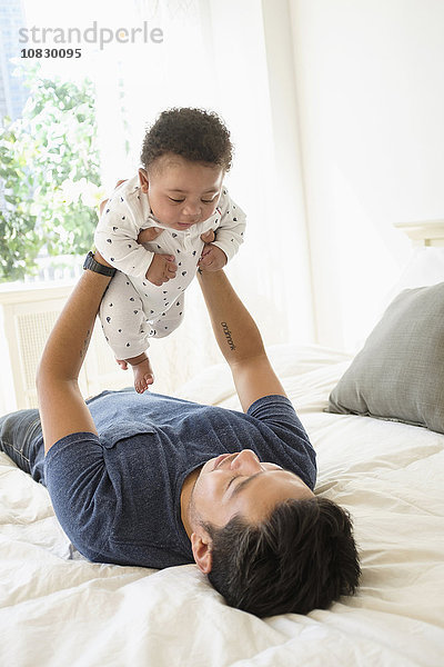 Vater hält seinen kleinen Sohn im Bett