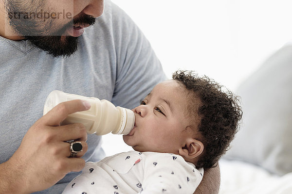 Vater füttert seinen Sohn mit der Flasche